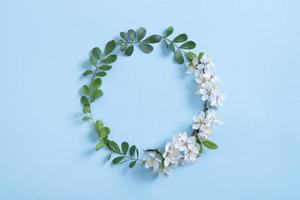 runder Wteath-Blumenrahmen für Ihren Frühlingstext. Blauer Hintergrund foto