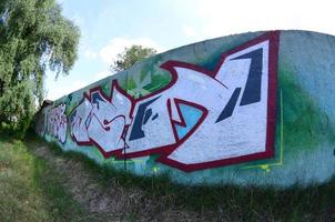 Straßenkunst. abstraktes Hintergrundbild eines vollständig fertiggestellten Graffiti-Gemäldes in Chromfüllung, grünem Hintergrund und roten Umrissen. Fisheye-Foto foto