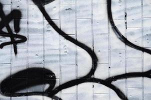 ein Fragment eines Graffiti-Musters, aufgebracht auf eine Wand aus kalten Fliesen, die mit einem feinen Kondensat bedeckt ist. das Konzept der Straßenkunst bei ungeeignetem Wetter foto