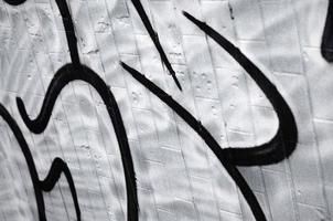 ein Fragment eines Graffiti-Musters, aufgebracht auf eine Wand aus kalten Fliesen, die mit einem feinen Kondensat bedeckt ist. das Konzept der Straßenkunst bei ungeeignetem Wetter foto