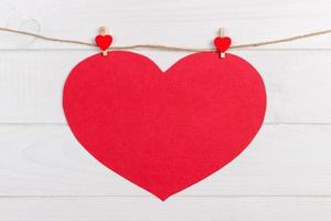 Rotes Herz der großen Liebe, das auf hölzernem Beschaffenheitshintergrund, Valentinstagkartenkonzept hängt foto
