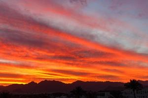 bunter orangefarbener Sonnenuntergang über den Berghügeln foto