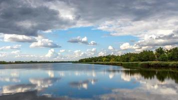 ein Fluss und die dramatische Wolkenlandschaft nach dem Regen. Wetterwechsel foto