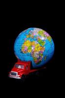 roter Spielzeuglastwagen, der einen Globus trägt foto