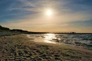 Buhnen ragen bei Sonnenuntergang ins Meer. die sonne scheint auf die ostsee. Landschaft foto