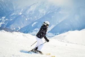 weibliche anfänger-skifahrerin bergab in den malerischen kaukasusbergen steile bergab solo foto