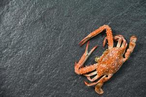 Schalentiere, Meeresfrüchte, Krabben, gekochtes Ozean-Gourmet-Abendessen, das auf dunklem Hintergrund gekocht wird. Blaue schwimmende Krabbe foto