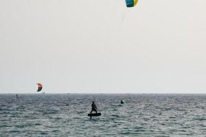 Windsurfen, Kitesurfen, Wasser- und Windsport mit Segeln oder Drachen foto