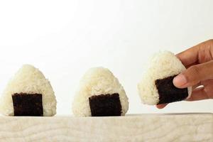 weibliche hand nehmen onigiri, japanisches essen, japanische reisbällchen foto