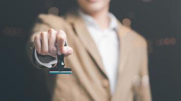 geschäftsmann, der stempel in der hand hält, konzept der bestätigung oder genehmigung der vereinbarung. Befugnis zur Genehmigung von Anträgen auf Bankdarlehensdokumente durch Sponsoring-, Verifizierungs- oder Annahmeverfahren foto