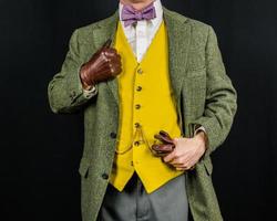 Porträt eines Mannes in Tweed-Anzug und Lederhandschuhen. Konzept des klassischen und exzentrischen britischen Gentleman foto