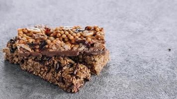 Müsliriegel. gesunder Snack. müsliriegel mit nüssen, schokolade auf betontischhintergrund. Platz kopieren foto