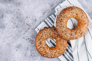 gesunder Bio-Vollkorn-Bagel auf Betontisch. Frühstücksbrot. kopierraum, draufsicht foto