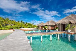 schönes tropisches malediven-resorthotel und insel mit strand und meer am himmel für urlaubshintergrundkonzept. Verbessern Sie die Farbverarbeitung. tropischer strand in malediven wasservillen und steg foto