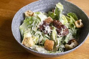 Caesar-Salat in einer Schüssel auf dem Tisch foto