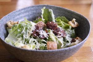 Caesar-Salat in einer Schüssel auf dem Tisch foto