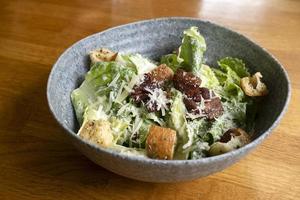 Caesar-Salat in einer Schüssel auf dem Tisch foto