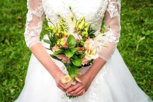 Hochzeitsstrauß in den Händen der Braut foto