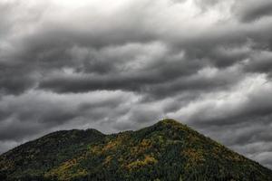 dunkle stürmische Wolken über dem Hügel foto