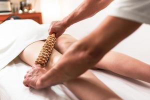 Holzrollenwerkzeug für die Anti-Cellulite-Massage. Beine massieren foto