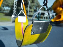 Nahaufnahme einer gelben Schaukel auf dem Kinderspielplatz foto