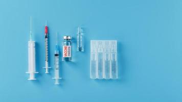 Ampulle des Impfstoffs mit einer Spritze auf blauem Hintergrund. foto