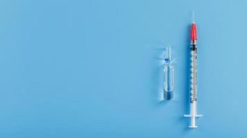 spritzen und ampulle mit dem impfstoff gegen das virus von krankheiten auf blauem hintergrund. foto