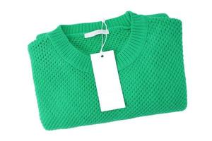 weißes leeres rechteckiges Kleidungsetikett auf grünem Strickpullover isoliert auf weißem Hintergrund foto