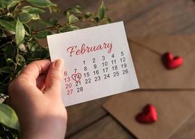 Kalender für Februar in einer weiblichen Hand. der 14. Februar. Valentinstag foto