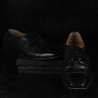 Paar schwarze männliche klassische Schuhe auf schwarzem Hintergrund. staubige Schuhe foto