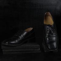 Paar schwarze männliche klassische Schuhe auf schwarzem Hintergrund. staubige Schuhe foto