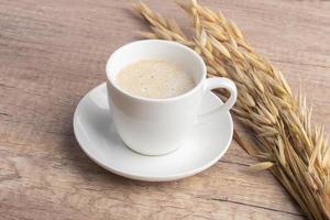 Heiße Haferflocken in weißer Tasse auf Holzhintergrund foto