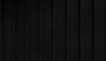 schwarzer Edelstahlhintergrund im Vintage-Ton. dunkle fenstertürwand mit kopierraum. linienmuster des vorhang- oder zinktapetenkonzepts. foto