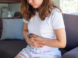 Eine Frau hat starke Bauchschmerzen. Menstruationsbeschwerden foto