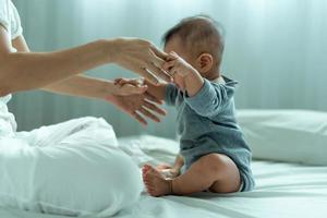 Säugling asiatisch. Ein asiatisches Baby vertraut der Hand seines Vaters, um aufzustehen. vater und sohn verbringen zeit miteinander foto