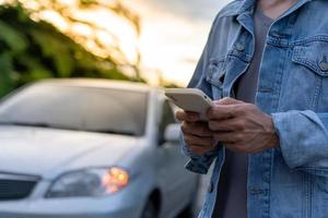 Sicherheit im Notfall. Mann wählt wegen einer Autopanne im Wald ein Handy für eine Notrufnummer. Die Wartung des Autos vor der Fahrt erhöht die Unfallsicherheit. foto