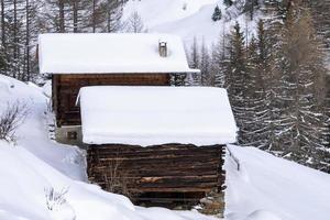 schneebedeckte holzblockhaushütte in den dolomiten foto