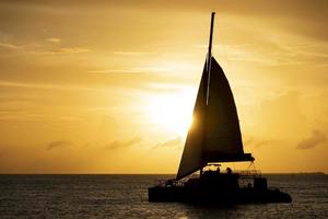 schöner sonnenuntergang mit segelbootsilhouette foto