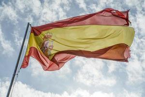 wehende spanische flagge im blauen himmel foto