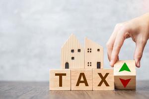 Steuerblock mit Hausmodell. immobilien, wohnungsbaudarlehen, besteuerung, zahlung und finanzkonzept foto