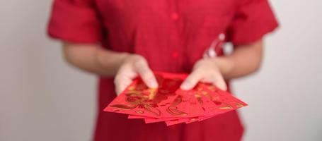 frau, die chinesischen roten umschlag, geldgeschenk für glücklichen mondneujahrsfeiertag hält foto