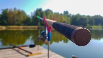 Angelrute auf dem Hintergrund eines Piers am Ufer eines Flusses oder Sees. Nebeliger Morgen. wilde Natur. das Konzept der Erholung auf dem Land. ein Artikel über einen Angeltag. foto