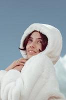 Porträt eines Mädchens mit weißem Pelzmantel im Winter foto