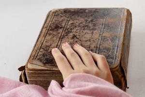 die Hand eines muslimischen Mädchens auf einem seltenen Koran foto