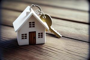 Immobilienkonzept - Schlüsselanhänger und Schlüssel auf weißem Holzhintergrund