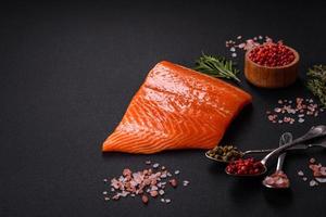 Filet vom rohen roten Lachsfisch mit Salz, Gewürzen und Kräutern foto