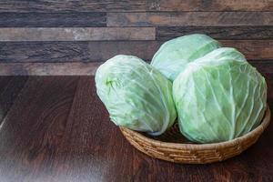 Kohl in einem Korb auf einem Holztisch foto