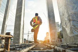 arbeiter, der ausrüstungssicherheitsgurt und sicherheitsleine trägt, die an hohen arbeitsplätzen an baustellenkonzepten des im bau befindlichen wohngebäudes arbeiten foto