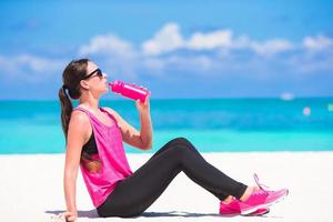 Frau Trinkwasser am Strand foto