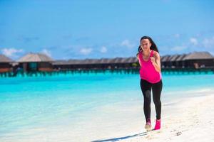 Malediven, Südasien, 2020 - Frau läuft an einem Strand in der Nähe eines Resorts foto
